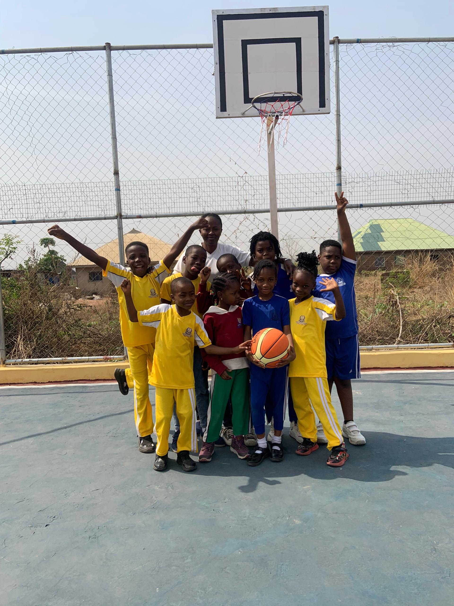 Noble Brains Academy basketball team and coach under the hoop