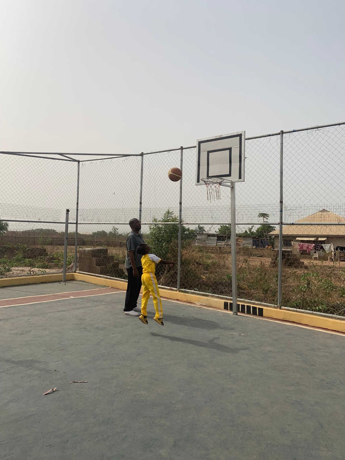 Young pupil leaping to shoot basketball on court